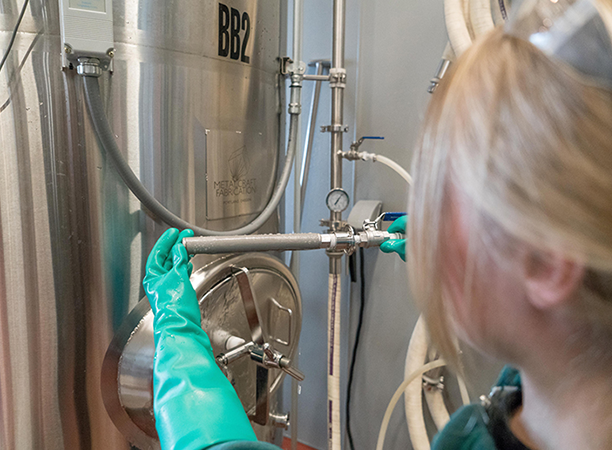 A blonde woman works on a water heater.