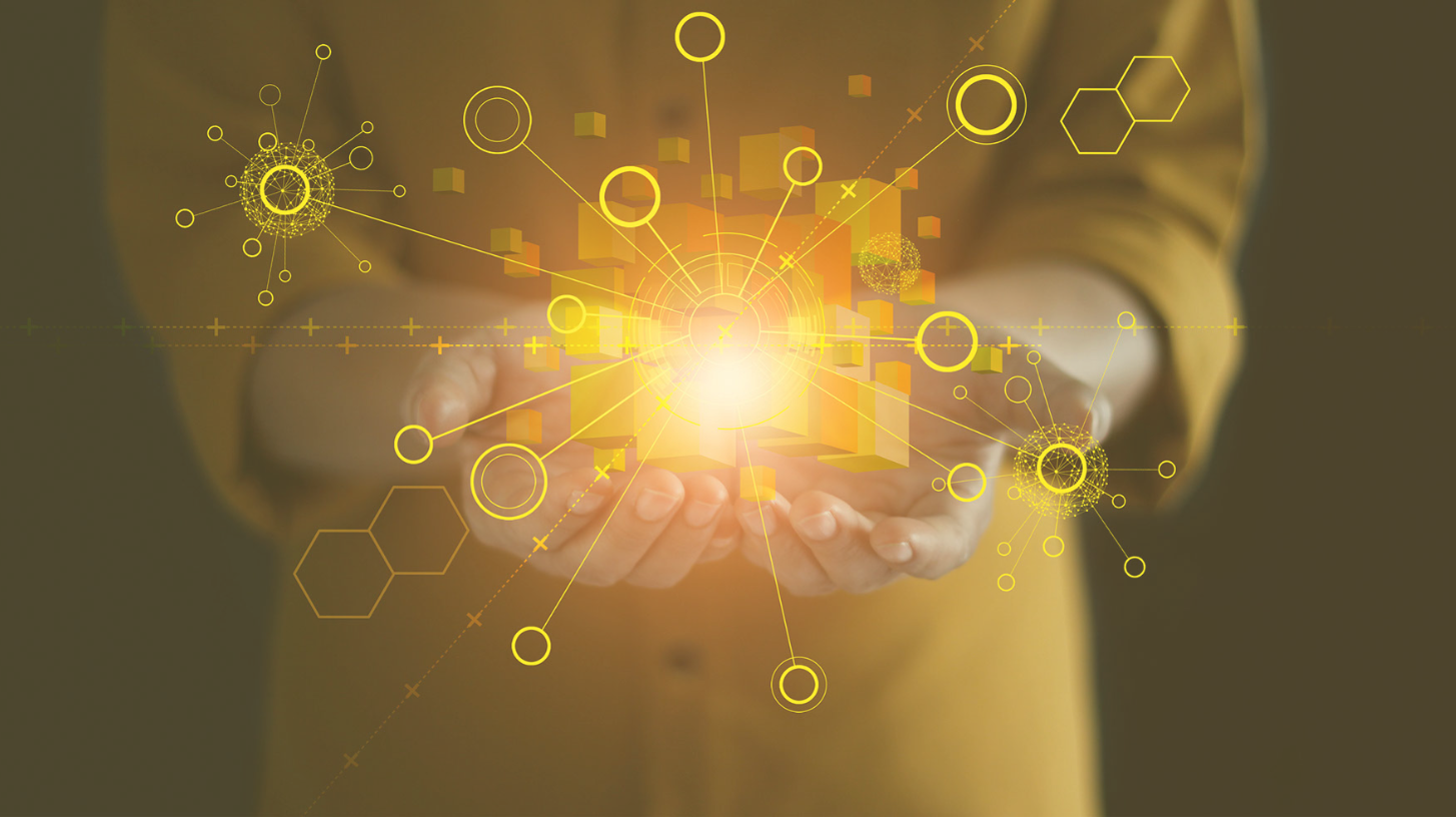 A person in a yellow shirt holds a light in their hands. A yellow graphic depicting digital connections lays over the light.
