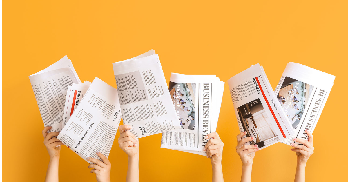 hands holding up newspapers